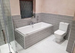 Large luxury bathroom with tiled in bath and grey metro tiles