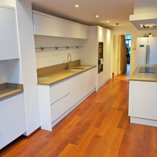 White handless German kitchenj with quartz worktops and solid oak flooring