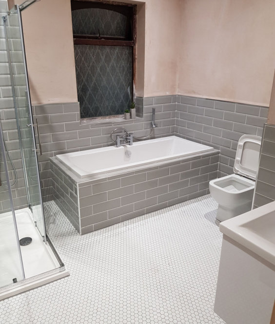 Large family bathroom with tiled in bath, grey metro tiles and white mosaic floor