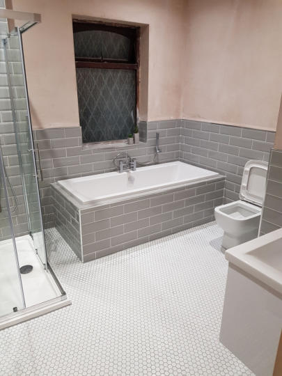 large family bathroom with tiled in bath using grey metro tiles. mosaic floor in white